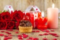 Cupcake with cherry in front of bouquet of red roses and cadles Royalty Free Stock Photo