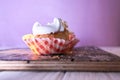 Cupcake with cream on a pastel background on a wooden table Royalty Free Stock Photo