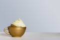 Cupcake with frosting and sprinkles, in golden cup Royalty Free Stock Photo