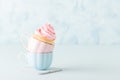 Cupcake with gentle pink cream decoration in two cups on blue pastel background. Royalty Free Stock Photo