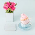 Cupcake with gentle pink cream decoration in two cups on blue pastel background. Royalty Free Stock Photo