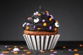 Cupcake on Halloween. Dessert on Halloween party. Muffin decorated with colored sprinkles, black frosting, icing Royalty Free Stock Photo