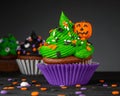 Cupcake on Halloween. Pumpkin Jack o lantern. Dessert on Halloween party. Muffin decorated with colored sprinkles Royalty Free Stock Photo