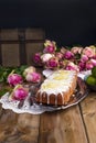 Cupcake with lime and white cream on an old tray, pink roses and a wooden background Royalty Free Stock Photo