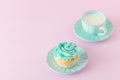 Cupcake with mint cream decoration and cup of milk and coffe on pink pastel background. Mother`s day greeting card