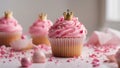 cupcake with pink icing and gold crown A festive photo of a pink cupcake with a princess crowns on top. The cupcake is in a pink Royalty Free Stock Photo