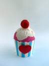 Cupcake pink whipped cream decorated with red heart and ball red on white background. Muffin blue e white stripe decoration line.