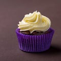 Cupcake in purple wrap on dark brown background. Minimalist. Copy space