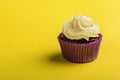 Cupcake in purple wrap on yellow background. Minimal. Copy space
