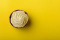 Cupcake in purple wrap on yellow background. Minimalism. Top view with copy space