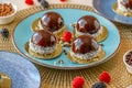 cupcake with raspberry set on a blue plate and chocolate decor on a beige table.Berry dessert. airy cake souffle