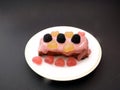 Cupcake with red icing and gummy hearts on a black background