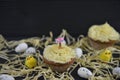Cupcake topped with a miniature person figurine holding a sign indicating i love Easter with some decorations Royalty Free Stock Photo
