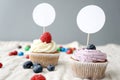 Cupcake topper mockup with two delicious gourmet cupcakes on a deep background with berries.