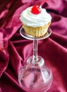 Cupcake with whipped cream and maraschino cherry