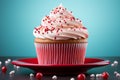 a cupcake with white frosting and sprinkles on a red plate Royalty Free Stock Photo