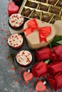 Cupcakes, chocolate and rose on a gray background