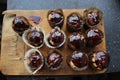 12 cupcakes in chocolate on a wooden board