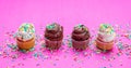 Cupcakes with colorful sprinkles on pink background Royalty Free Stock Photo