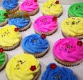 Cupcakes with Colourful creamy icing toppling