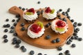 cupcakes with cottage cheese on vintage tray-tasty muffin with strawberry and kiwi on wooden plate