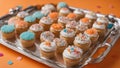 cupcakes with cream Small party cakes with white icing and colorful sprinkles on a silver tray.