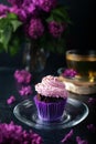 Cupcakes with creamy curd cream with a cup of tea on a lilac background