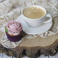 Cupcakes decorated with cream flowers: rose on a wooden background with a lacy napkin with cup of coffee. Festive card. Breakfast Royalty Free Stock Photo