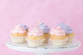 Cupcakes decorated with violet and pink buttercream on shabby shic stand on pastel pink background Royalty Free Stock Photo