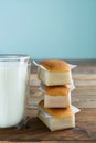 Cupcakes with glass of milk on wooden table with blue background. Copy space. Vertical photo. Handmade madeleines