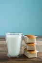 Cupcakes with glass of milk on wooden table with blue background. Copy space. Vertical photo. Handmade madeleines