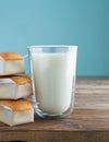 Cupcakes with glass of milk on wooden table with blue background. Copy space. Vertical photo. Handmade madeleines