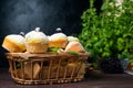 Cupcakes with mint and blackcurrant leaves in powdered sugar on a black background, a wooden basket with cupcakes and Royalty Free Stock Photo