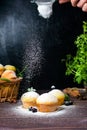 Cupcakes with mint and blackcurrant leaves in powdered sugar on a black background, a wooden basket with cupcakes and Royalty Free Stock Photo