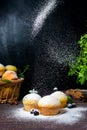 Cupcakes with mint and blackcurrant leaves in powdered sugar on a black background, a wooden basket with cupcakes and Royalty Free Stock Photo