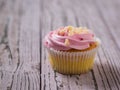 Cupcakes with pink cream and grated nuts on a wooden table. Selective focus. Royalty Free Stock Photo