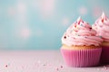 Cupcakes with pink frosting and sprinkles on blue background
