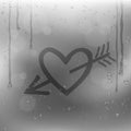 Cupid arrow heart draw on rainy window