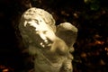 Cupid cement sculpture god of love with dark background Royalty Free Stock Photo