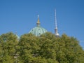 Cupola of Berlin cathedral and Fernsehturm above trees of Lustgarten park