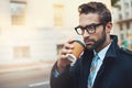 Cuppa coffee before he clocks into work. a stylish man drinking a cup of coffee while out in the city.