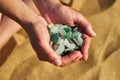 Cupped hands hold sea glass collected from the beach