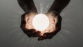 Cupped hands holding a brightly radiating sphere of light Royalty Free Stock Photo