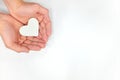 Cupped hands holding a white heart in white background. Kindness and pure love concept. Royalty Free Stock Photo