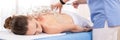 Cupping Therapy Banner. Young female physiotherapist applying glass suction banks on back of her patient.