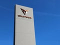 Cupra logo outside the car dealership of the area, against a blue sky . It is the symbol of the spanish sport car manufacturer