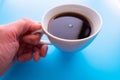 Cups of black tea in the hands of men on a blue background. with copy space. top view Royalty Free Stock Photo