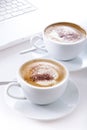 Cups of cappuccino with laptop Royalty Free Stock Photo
