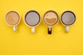 Cups of coffe - black and with milk - on yellow background. Creative concept of hot drinks. Top view, copy space