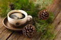 Cups of coffee next to cones and a pine branch